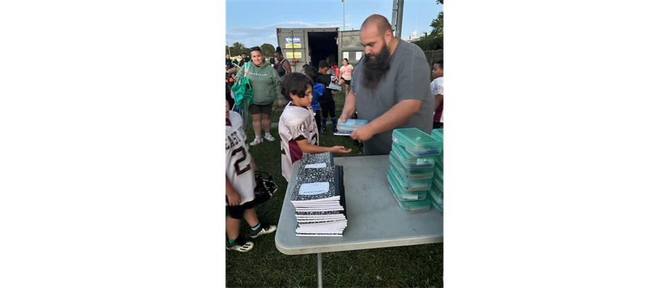 VP John Raye handing out school supplies to the players.